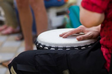 Bir adam yoga festivalinde açık havada bongo davulu çalıyor..