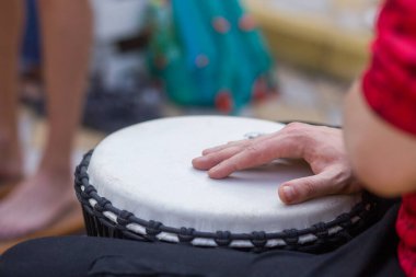 Bir adam yoga festivalinde açık havada bongo davulu çalıyor..