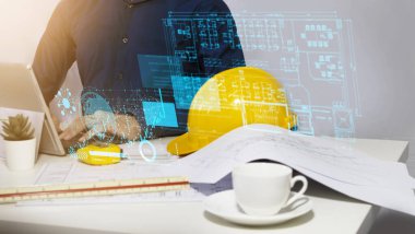 Mühendisler tasarım ve sistem çalışmaları, inşaat güvenliği, inşaat işi ve gayrimenkul üzerinde oturup çalışıyorlar.