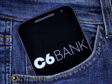 Kotun cebindeki akıllı telefon ekranında C6 Bank logosu var. C6 Bank Brezilya 'nın dijital bankasıdır..