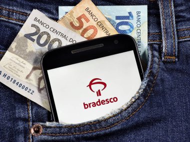 Bradesco ve Visa bayraklarının Banco Bradesco uygulama logosuna sahip akıllı telefon. Dijital ödeme sistemi. Bradesco bir Brezilya bankasıdır, şirket olarak kurulmuştur..