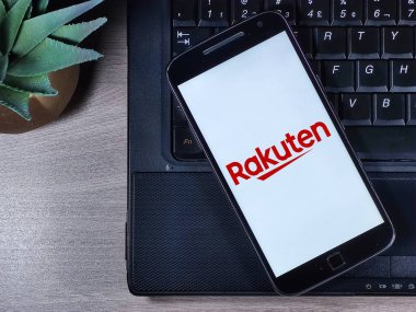 Akıllı telefon ekranında Rakuten logosu var. Rakuten, Inc. online alışveriş ve video izleme gibi hizmetler sunan bir Japon teknoloji şirketi..