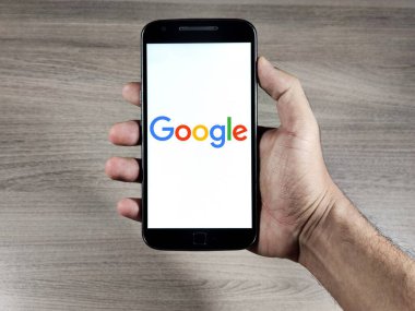 Akıllı telefon ekranında Google logosu. Google, çok uluslu bir internet ve teknoloji şirketidir..