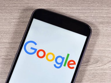 Akıllı telefon ekranında Google logosu. Google, çok uluslu bir internet ve teknoloji şirketidir..