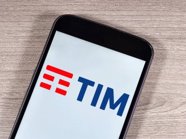 Akıllı telefon ekranında TIM logosu var. TIM (Telekom Italia Mobile kısaltması), merkezi İtalya 'da bulunan bir cep telefonu şirketidir..