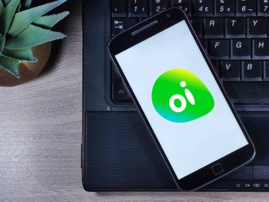 Akıllı telefon ekranında operatör Oi logosu var. Daha önce Telemar olarak bilinen Oi, Brezilya 'da telekomünikasyon servisinde imtiyaz sahibi..