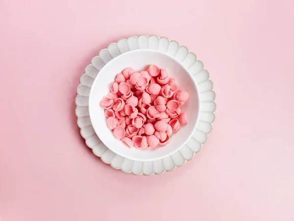 Pink Cereal with strawberry flavour in white bowl on pink background. Breakfast concept, negative space. selective focus