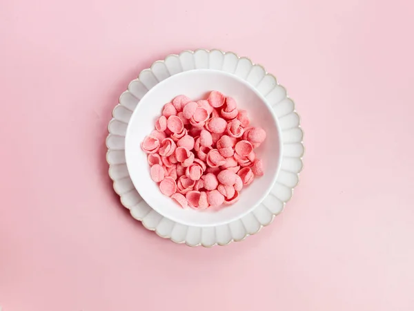 Pembe mısır gevreği, pembe arka planda beyaz kasede çilek aromalı. Kahvaltı konsepti, negatif alan. seçici odak