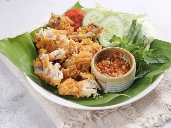 Ayam Geprek Endonezya usulü kızarmış tavuk ve acılı acılı biber sosu. Şu anda Endonezya ve komşu ülkelerde bulunan Ayam Geprek, Köken Yogyakarta