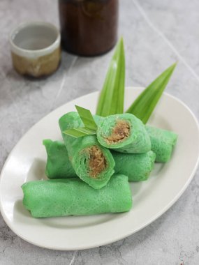 kue dadar gulung, glutinous rice, hindistan cevizi ve palmiye şekerinden yapılmış bir tatlı. Malezya, Endonezya ve Singapur 'da popülerdir. mermer arka planda servis edilir