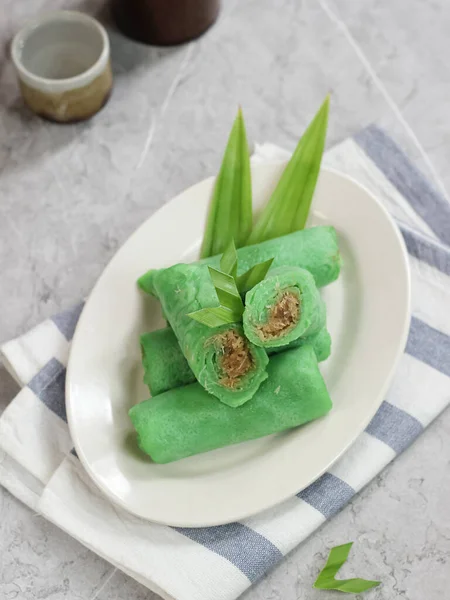 kue dadar gulung, glutinous rice, hindistan cevizi ve palmiye şekerinden yapılmış bir tatlı. Malezya, Endonezya ve Singapur 'da popülerdir. mermer arka planda servis edilir
