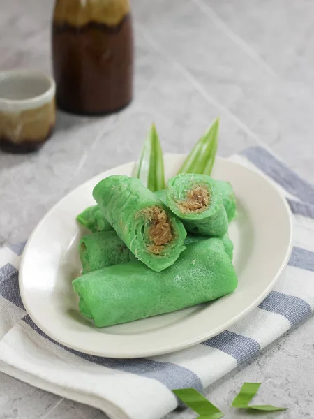 kue dadar gulung, glutinous rice, hindistan cevizi ve palmiye şekerinden yapılmış bir tatlı. Malezya, Endonezya ve Singapur 'da popülerdir. mermer arka planda servis edilir