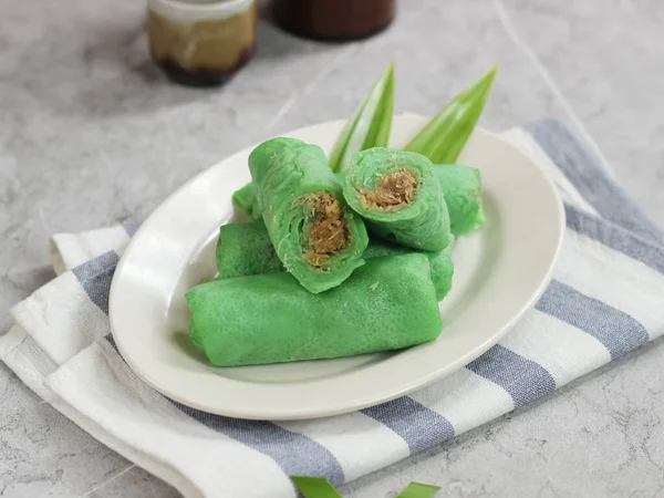 kue dadar gulung, glutinous rice, hindistan cevizi ve palmiye şekerinden yapılmış bir tatlı. Malezya, Endonezya ve Singapur 'da popülerdir. mermer arka planda servis edilir