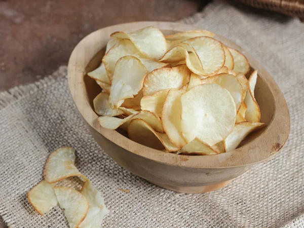 Keripik singkong. Cassava cipsi ya da tapyoka cipsi, ince dilimlenmiş ve kızarmış Cassava 'dan yapılan geleneksel bir aperatiftir. Tahta kasede servis edilmiş. Seçici odak