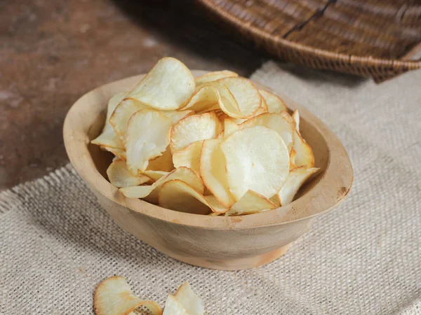 Keripik singkong. Cassava cipsi ya da tapyoka cipsi, ince dilimlenmiş ve kızarmış Cassava 'dan yapılan geleneksel bir aperatiftir. Tahta kasede servis edilmiş. Seçici odak