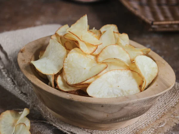Keripik singkong. Cassava cipsi ya da tapyoka cipsi, ince dilimlenmiş ve kızarmış Cassava 'dan yapılan geleneksel bir aperatiftir. Tahta kasede servis edilmiş. Seçici odak