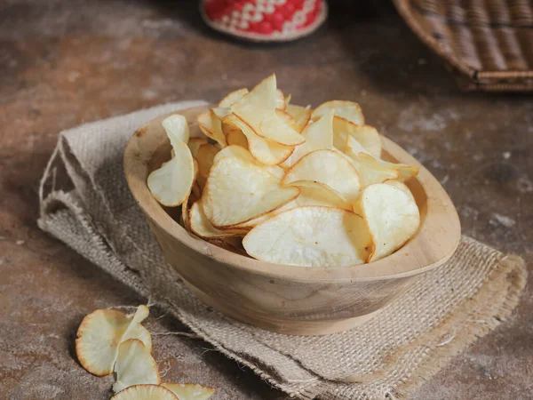 Keripik singkong. Cassava cipsi ya da tapyoka cipsi, ince dilimlenmiş ve kızarmış Cassava 'dan yapılan geleneksel bir aperatiftir. Tahta kasede servis edilmiş. Seçici odak