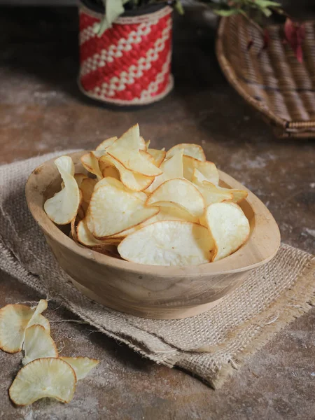 Keripik singkong. Cassava cipsi ya da tapyoka cipsi, ince dilimlenmiş ve kızarmış Cassava 'dan yapılan geleneksel bir aperatiftir. Tahta kasede servis edilmiş. Seçici odak