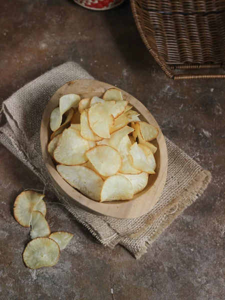 Keripik singkong. Cassava cipsi ya da tapyoka cipsi, ince dilimlenmiş ve kızarmış Cassava 'dan yapılan geleneksel bir aperatiftir. Tahta kasede servis edilmiş. Seçici odak