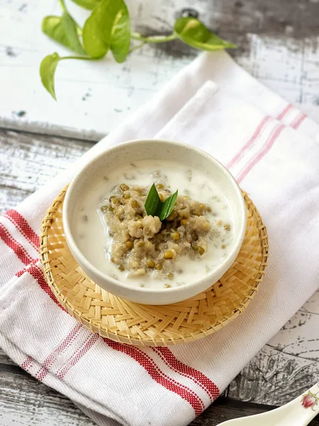 Bubur Kacang Hijau, Endonezya tatlı ya da kahvaltısı hindistancevizi sütü ve palmiye şekeriyle pişirilmiş pandan yapraklarıyla. Beyaz dokular yüzeye çıkıyor. Seçici odak