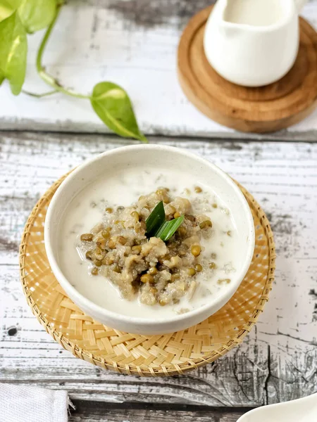 Bubur Kacang Hijau, Endonezya tatlı ya da kahvaltısı hindistancevizi sütü ve palmiye şekeriyle pişirilmiş pandan yapraklarıyla. Beyaz dokular yüzeye çıkıyor. Seçici odak