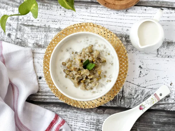 Bubur Kacang Hijau, Endonezya tatlı ya da kahvaltısı hindistancevizi sütü ve palmiye şekeriyle pişirilmiş pandan yapraklarıyla. Beyaz dokular yüzeye çıkıyor. Seçici odak