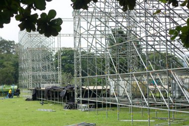 İnşaat alanındaki metal iskelenin farklı parçaları. İşçiler bir konser sahnesi inşa ediyorlar. Sahne ekipmanı.