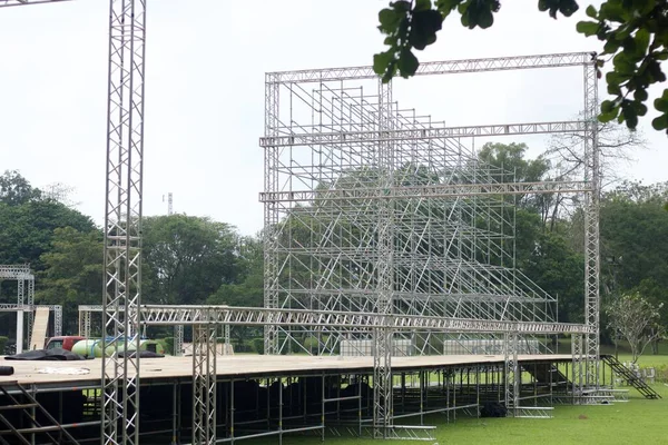 Different parts of metal scaffold on the construction field. Workers build a concert stage. Stage equipment.