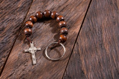 Catholic denarius and crucifix on wooden background