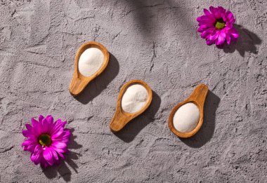 Üç tahta kaşıkta hidrolize kolajen tozu.