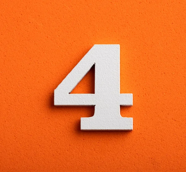 Τέσσερα Λευκό Ξύλινο Αριθμό Πορτοκαλί Φόντο — Φωτογραφία Αρχείου