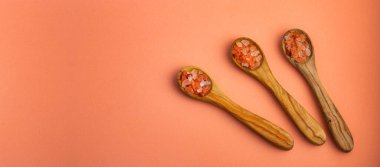 Üç tahta kaşıkta ince taneli Himalaya pembe tuzu ve kristalleri