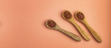 Chenopodium kinoası - Üç tahta kaşıkta kırmızı kinoa tohumu