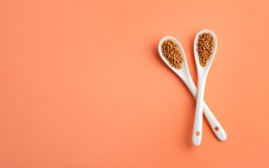 Sinapis alba - İki seramik kaşıkta organik hardal taneleri