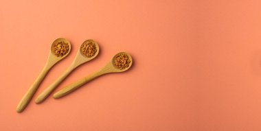 Üç tahta kaşıkta organik çemen otu tohumları - foenum graecum