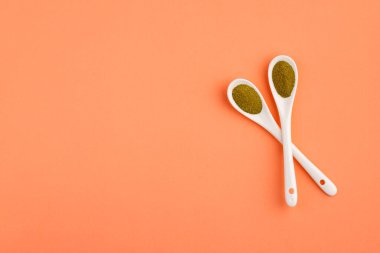 İki seramik kaşıkta organik yeşil toz - Moringa