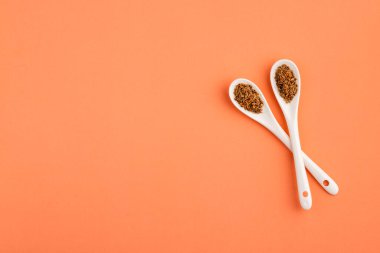 Pimpinella anisum - İki seramik kaşıkta baharatlı anason tohumu