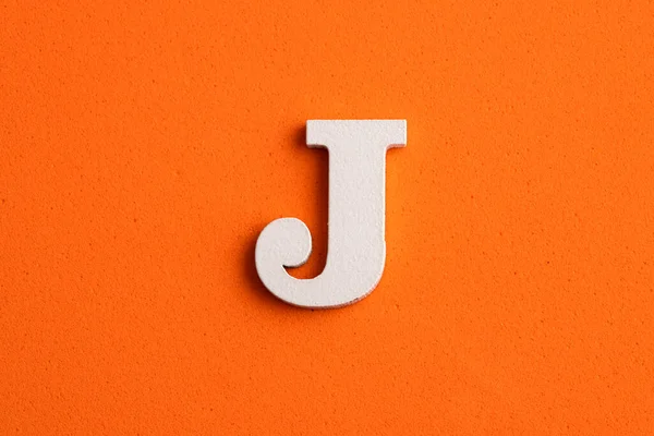 アルファベット文字J オレンジの泡の背景に白い木の作品 — ストック写真