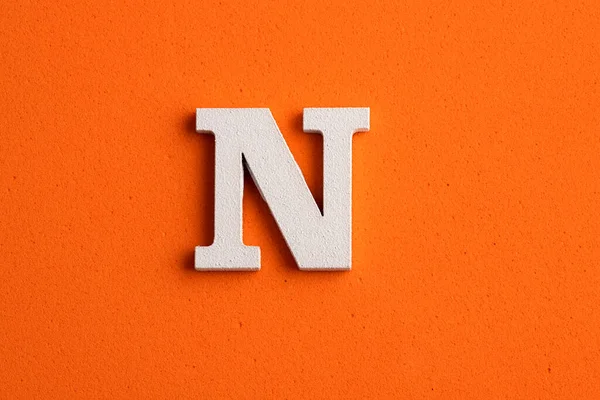 Alfabe harfi N-Beyaz tahta parçası turuncu köpüklü arka plan