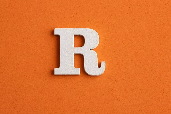 アルファベット文字R オレンジの泡の背景に白い木の作品 — ストック写真