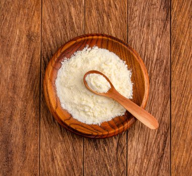 Kase ve kaşıkta besin içeren süt tozu.