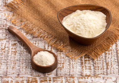 Kase ve kaşıkta besin içeren süt tozu.