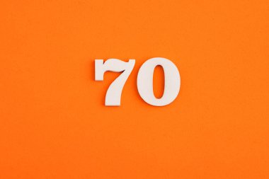 White wooden number 70 on eva rubber orange background