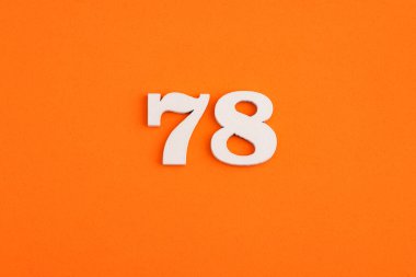 White wooden number 78 on eva rubber orange background