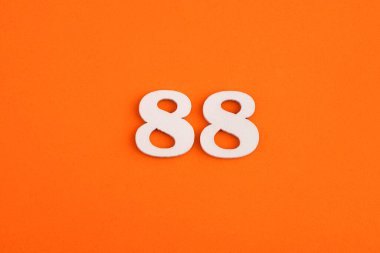 White wooden number 88 on eva rubber orange background