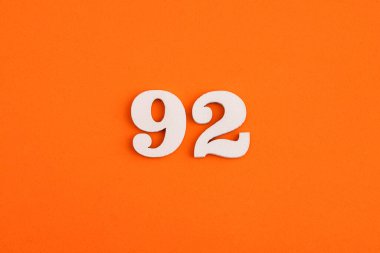 White wooden number 92 on eva rubber orange background