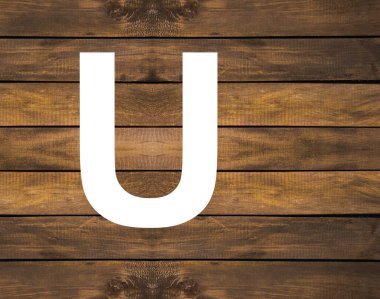 Tahta zemin üzerinde beyaz delikte büyük harf alfabe.