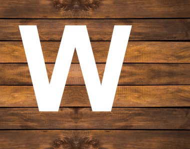 Tahta zemin üzerinde beyaz delikte alfabenin W büyük harfi