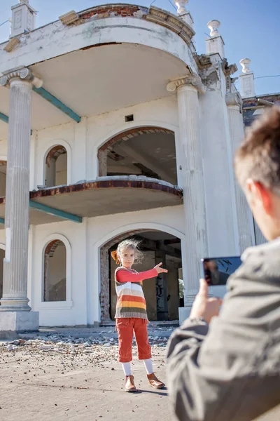 Девушка-блогер записывает фильм и делает селфи над заброшенным зданием для своего канала, местного туризма — стоковое фото
