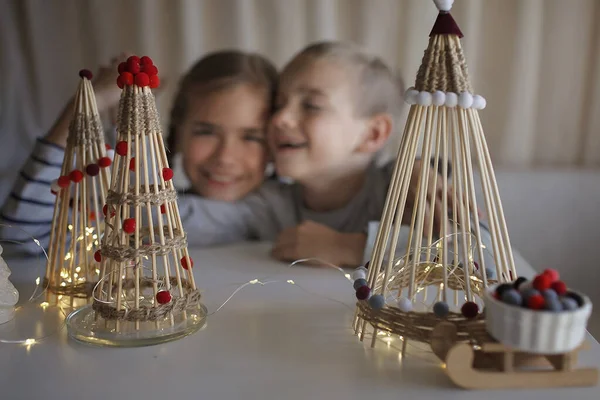 Τα παιδιά ονειρεύονται κοντά στην τέχνη Χριστουγεννιάτικο δέντρο από μπαμπού μπαστούνια, επαναχρησιμοποιήσιμο στολίδι, DIY διακόσμηση του νέου έτους — Φωτογραφία Αρχείου